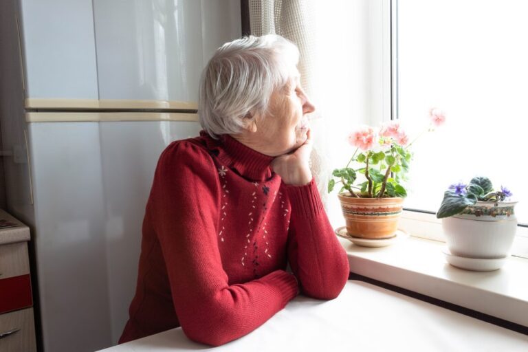 woman sitting alone looking out a window