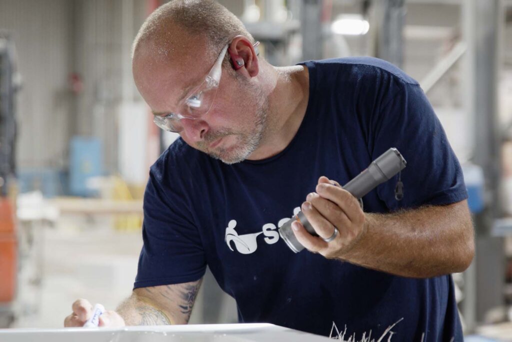 worker inspecting the tub during the manufacturing process