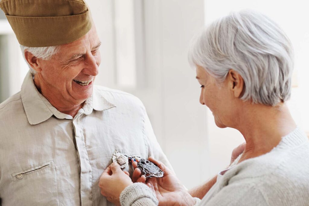 woman pinning a medal on a veteran