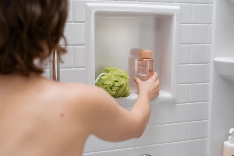 Woman reaching for shampoo in walk-in shower