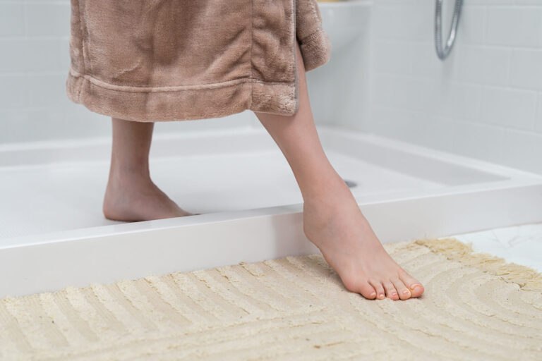 Woman stepping out of a Safe Step walk-in shower